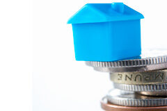 ¿Fin al devengo de la plusvalía municipal cuando el contribuyente tiene una pérdida patrimonial? Casita azul encima de monedas