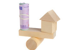 Las garantías en beneficio del expropiado Balanza de madera con una casita y un rollo de billetes de euro