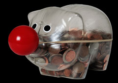 Un hucha de cerdo llena de monedas y con nariz de payaso.