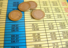 Una hoja con cifras y unas monedas