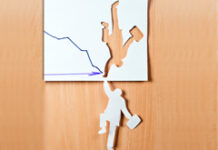 La huida del concurso En un papel dibujado una flecha hacía abajo y recortado una silueta de un hombre, y esa silueta recortada cuelga hacía abajo