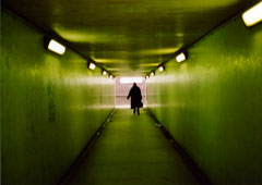 Una persona con un maletín andando por un túnel.