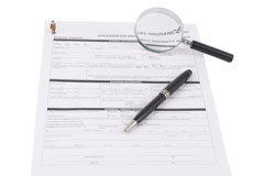 La importancia del contrato de colaboración público-privada en época de recesión Un contrato, sobre él hay un boligrafo y una lupa.