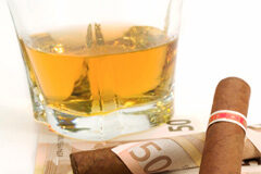 Suben los impuestos: alcohol y tabaco Una vaso con bebida y un puro envuelto en un billete de 50 euros
