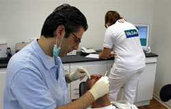 Soy dentista y me quiero jubilar a los 68 años Un dentista en su consulta con un paciente