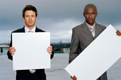 ¿Puede protegerse un eslogan en España? Dos personas sosteniendo unos fondos blancos.