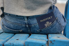 ¿Por qué es importante contratar a un abogado especialista en extranjería? Persona sentada con un pasaporte en el bolsillo