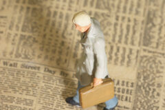 Extensión y límites al derecho de información del socio en las cooperativas de crédito Figura de hombre con maletín andando encima de un periódico