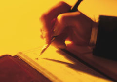 Una mano con un bolígrafo firmando un documento. Una mano con un bolígrafo firmando un documento.