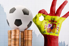 El Derecho de la competencia y el Fútbol profesional: ahora las ayudas de Estado Balón de futbol sobre monedas y con una mano pintada como la bandera española
