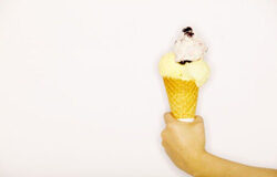 Cesión de uso de medios de frío por fabricantes de helados a los distribuidores Una mano sujetando un helado con cucurucho.