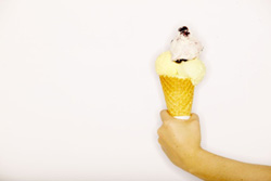 Una mano sujetando un helado con cucurucho.