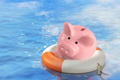 Las familias sobreendeudadas tendrán que esperar seis meses o más … Una hucha agarrada por un flotador en una piscina