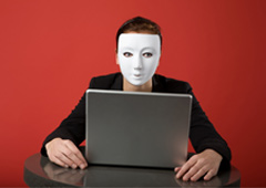 Una mujer con una máscara blanca delante de un ordenador