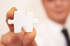 Competencia referencial o benchmarking Una mano con una ficha de puzzle