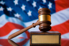 Peculiaridades del sistema judicial norteamericano Un mazo delante de una bandera de Estados Unidos