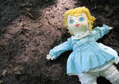 Una muñeca de trapo tirada en la tierra.