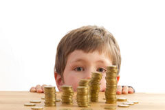 Los menores de edad en el derecho administrativo sancionador Un niño mirando unos montones de monedas