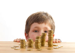 Un niño mirando unos montones de monedas
