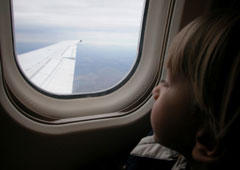Un niño mira por la ventanilla de un avión