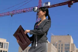 Una mujer en una construcción sacando un plano.
