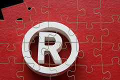 Las Marcas y Nombres Comerciales Notorios y de Renombre: una clase privilegiada en el Ordenamiento Jurídico Español Aparece la marca de registado con un puzzle rojo detrás