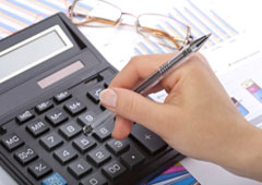 Una mano usando una calculadora. Una mano usando una calculadora.