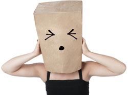 Una mujer con una bolsa en la cabeza tratando de no oír el ruído.