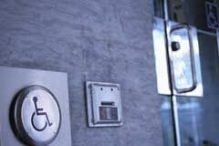 Obras de accesibilidad en comunidades de propietarios Una señal de discapacitado y al lado una puerta