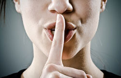 Manejar el silencio administrativo en momentos de cambios legislativos Una chica tapándose la boca en señal de silencio