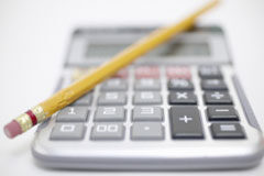 Actividad Económica VS Beneficios Fiscales Una calculadora con un lápiz encima.