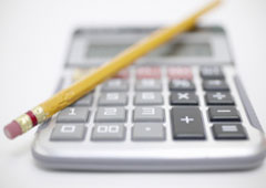 Una calculadora con un lápiz encima.