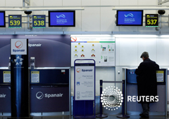 Un pasajero de Spanair llena el papeleo en el cerrado Spanair mostradores de facturación en el aeropuerto madrileño de Barajas