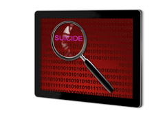 Pantalla de un portátil con un lupa sobre la palabra suicide Pantalla de un portátil con un lupa sobre la palabra suicide