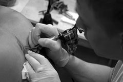 Los tatuajes, la propiedad intelectual o cómo paralizar el estreno de una película Una persona haciendo un tatuaje en la espalda a otra.