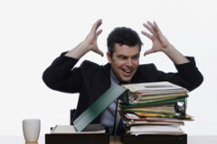 Obligaciones de la empresa ante el acoso laboral Persona con montones de documentos