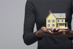 La doble venta inmobiliaria (I) Un hombre con una casa en miniatura en la mano